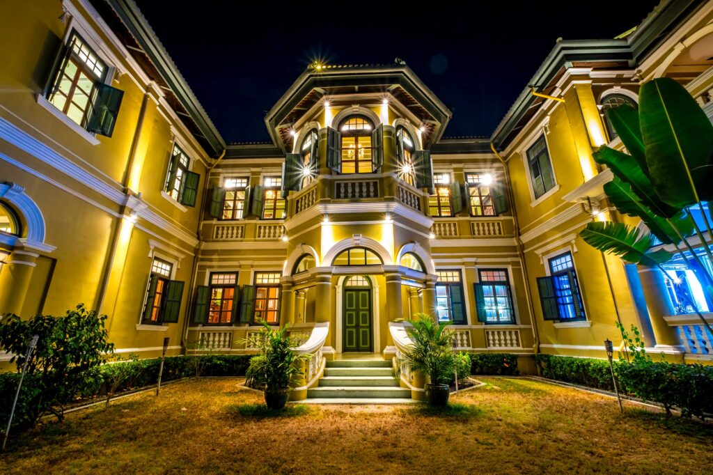 Luxury colonial-style villa illuminated at night with elegant architecture and landscaped entrance – premium luxury property showcased by BNB Realtors in Bangalore.